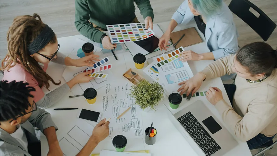 میز کار تیم طراحی با لپتاپ و ابزارهای برنامهریزی رابط کاربری